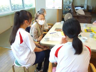 小牧市内の福祉施設での福祉体験学習の様子。学生が高齢者福祉施設のご利用者の方との会話を楽しんでいる。