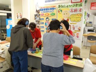 福祉展の様子。高齢者疑似体験で耳の聞こえにくさを体験するため、ヘッドフォンを装着している。