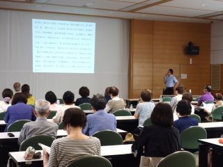 ボランティア勉強会の様子。講師の方がプロジェクターを見ながら参加者に講義をしている。