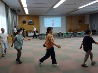 ボランティア勉強会の様子。ウォーキングアプリのアルコを使った講義で、参加者が会場内を歩いている。