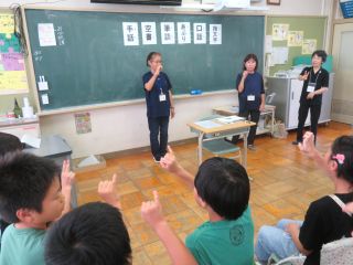 小牧市内小学校での福祉実践教室の様子。手話ボランティアが子どもたちに手話を教えている。